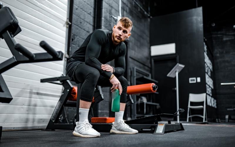 a person sitting on a bench in a weight room