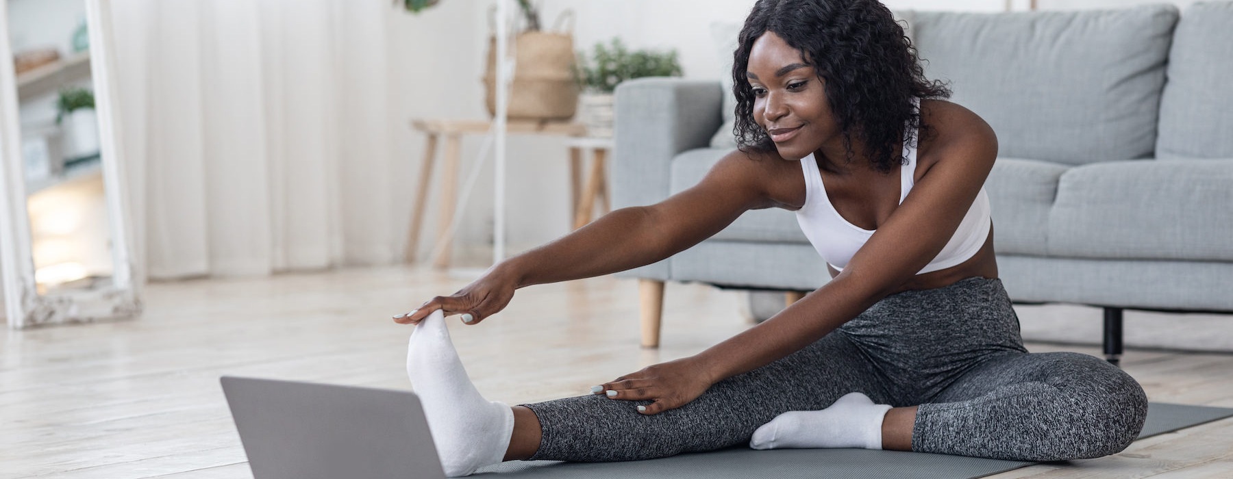 a woman stretching in front of a laptop